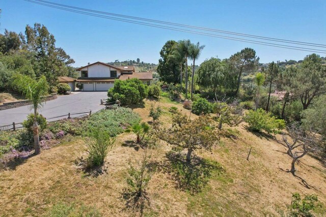 view of yard featuring concrete driveway, fence, and a garage