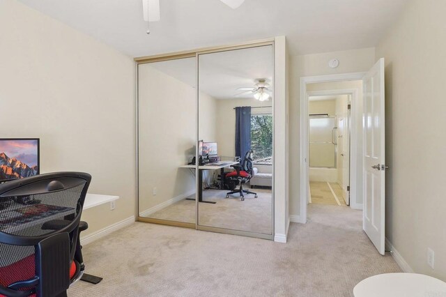 office space featuring baseboards, a ceiling fan, and carpet