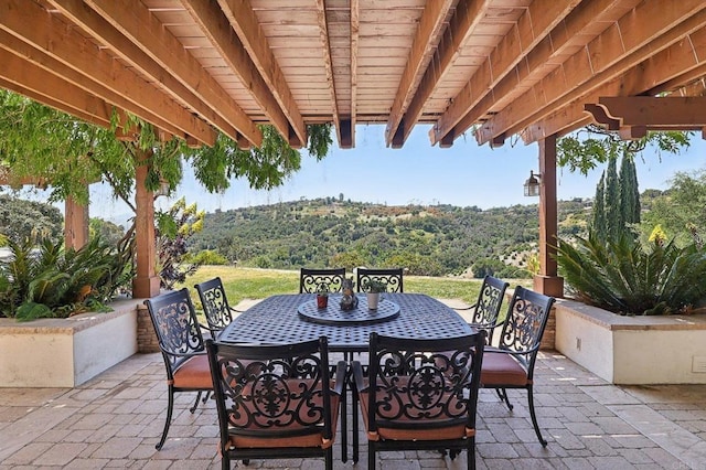 view of patio / terrace with a view of trees and outdoor dining space