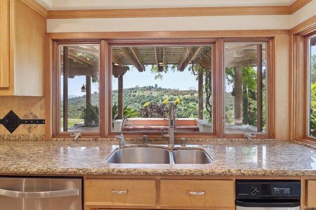 kitchen with crown molding, light stone counters, a sink, and dishwasher