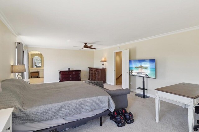 carpeted bedroom featuring arched walkways, baseboards, ornamental molding, and ceiling fan
