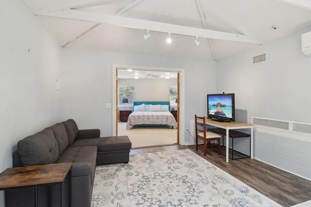 bedroom featuring visible vents, track lighting, vaulted ceiling with beams, and wood finished floors