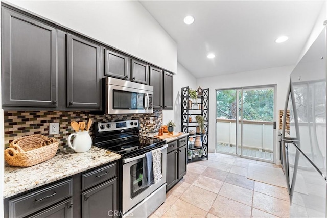 kitchen with appliances with stainless steel finishes, tasteful backsplash, light stone countertops, lofted ceiling, and recessed lighting