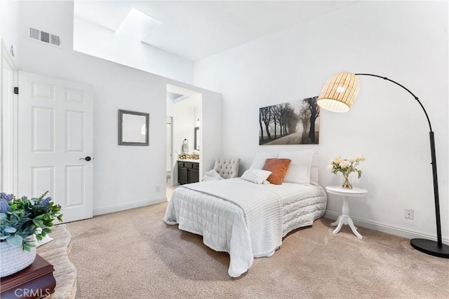 carpeted bedroom with baseboards, visible vents, and ensuite bathroom