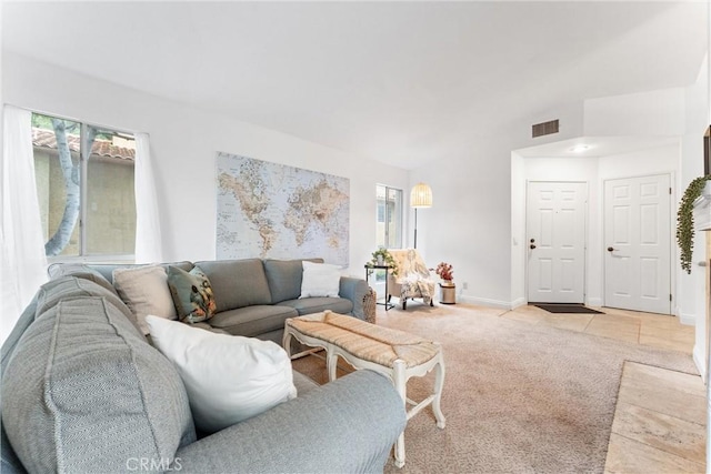 living room with baseboards, light carpet, lofted ceiling, and visible vents