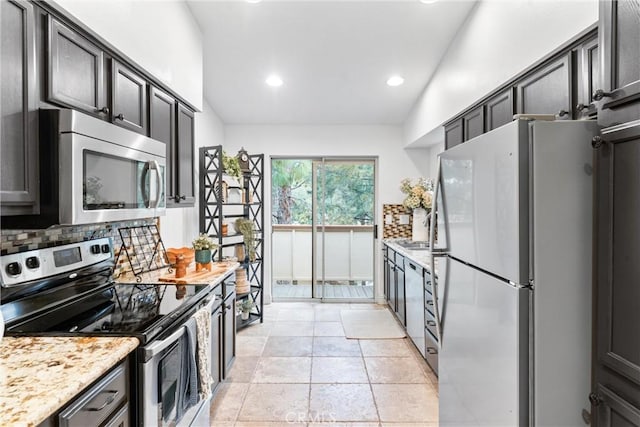 kitchen with recessed lighting, decorative backsplash, light stone counters, and stainless steel appliances