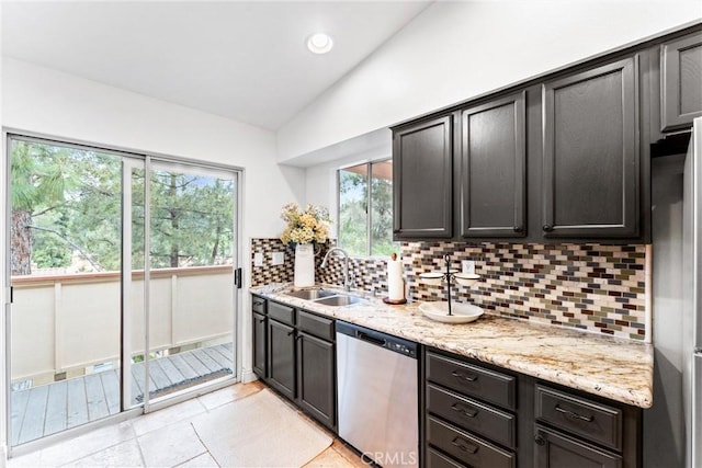 kitchen featuring dishwasher, plenty of natural light, a sink, backsplash, and vaulted ceiling