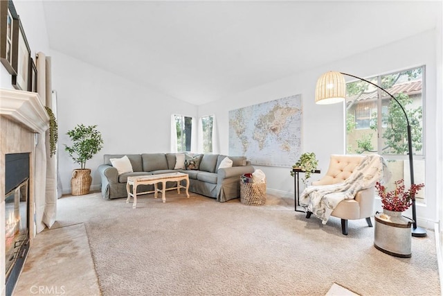 living area with carpet floors, baseboards, vaulted ceiling, and a fireplace