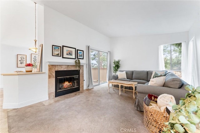 carpeted living room with a tiled fireplace and a wealth of natural light