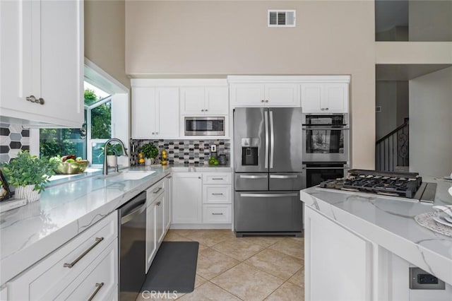 24661 Las Patranas, Yorba Linda, CA 92887 - kitchen featuring light stone countertops, appliances with stainless steel finishes, a sink, backsplash, and visible vents