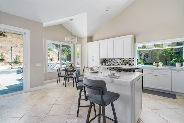 24661 Las Patranas, Yorba Linda, CA 92887 - kitchen with white cabinets, a breakfast bar, decorative backsplash, light tile patterned floors, and vaulted ceiling