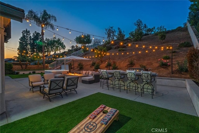 24661 Las Patranas, Yorba Linda, CA 92887 - patio terrace at dusk featuring fence, an outdoor living space with a fire pit, a yard, and outdoor dry bar