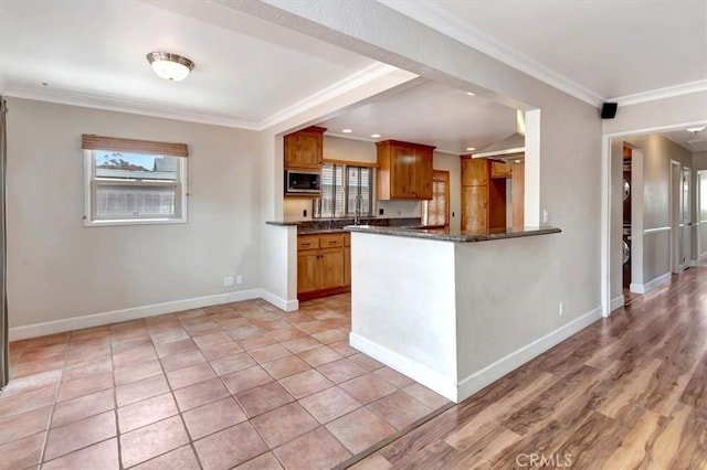 34605 Calle Portola, Dana Point, CA 92624 - kitchen with crown molding, a peninsula, baseboards, stainless steel microwave, and brown cabinets