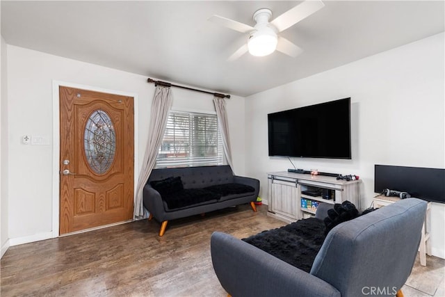living room with baseboards, a ceiling fan, and wood finished floors