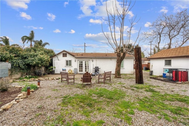 back of property with a patio, stucco siding, french doors, and fence