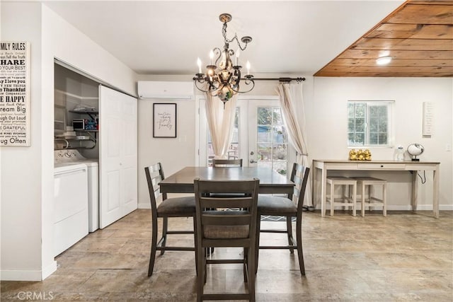 dining area with separate washer and dryer, baseboards, stone finish flooring, and a notable chandelier