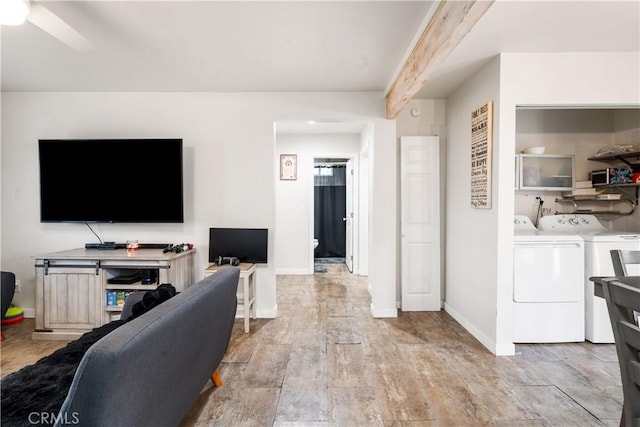 living room featuring washing machine and clothes dryer, baseboards, and ceiling fan