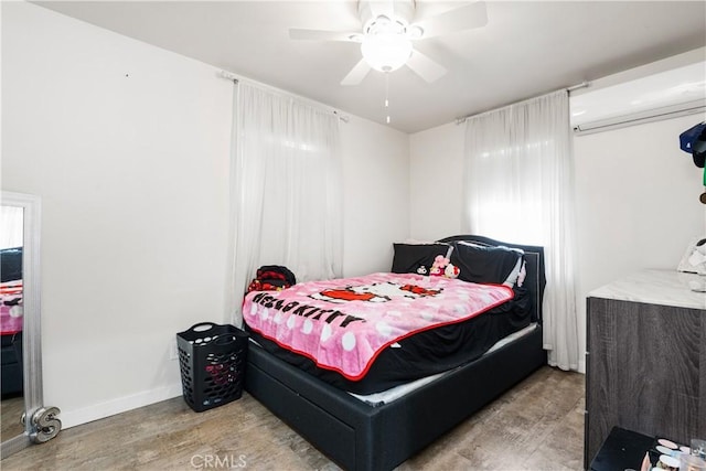bedroom with baseboards, ceiling fan, and wood finished floors
