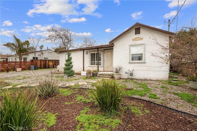 back of property with fence and stucco siding