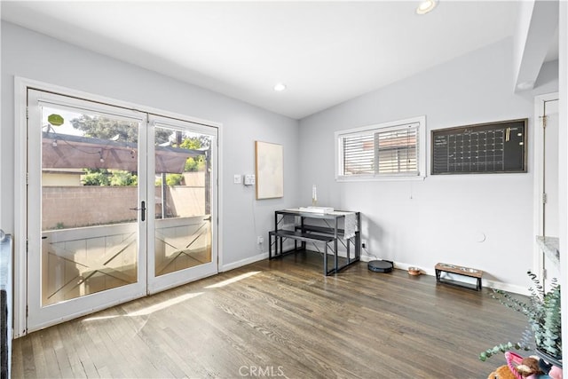 doorway with baseboards, vaulted ceiling, recessed lighting, and wood finished floors
