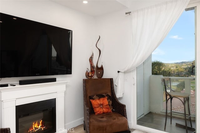 living area featuring recessed lighting, a lit fireplace, and light wood-type flooring