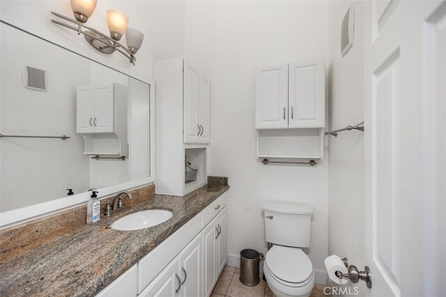 half bath with vanity, tile patterned floors, visible vents, and toilet
