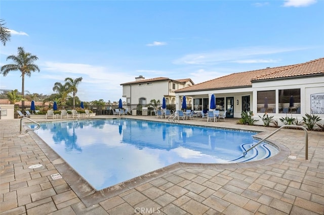 pool featuring fence and a patio area