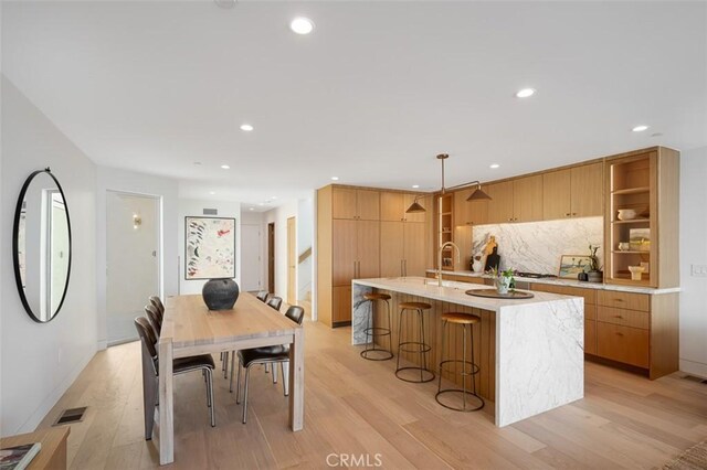 207 Canal St, Newport Beach, CA 92663 - kitchen featuring light countertops, light wood-style flooring, modern cabinets, a kitchen island with sink, and recessed lighting