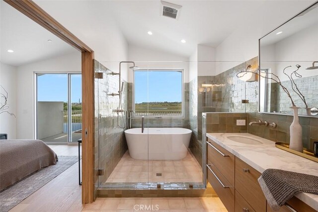 207 Canal St, Newport Beach, CA 92663 - bathroom with plenty of natural light, vaulted ceiling, a soaking tub, vanity, and a tile shower