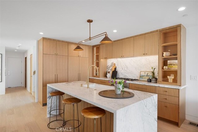 207 Canal St, Newport Beach, CA 92663 - kitchen with open shelves, light wood-style flooring, a kitchen breakfast bar, light stone countertops, and recessed lighting