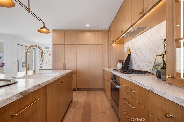 207 Canal St, Newport Beach, CA 92663 - kitchen featuring stainless steel range with gas cooktop, light wood-style floors, light stone counters, decorative light fixtures, and recessed lighting