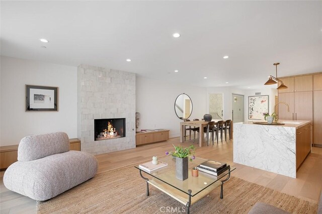 207 Canal St, Newport Beach, CA 92663 - living area with light wood-style flooring, recessed lighting, and a stone fireplace