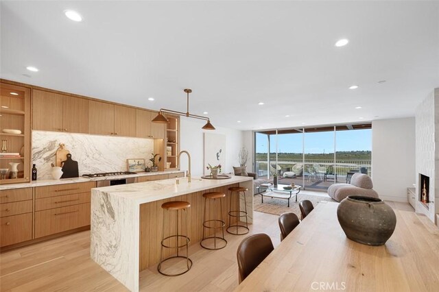 207 Canal St, Newport Beach, CA 92663 - kitchen with open shelves, light wood-style flooring, open floor plan, a breakfast bar, and recessed lighting