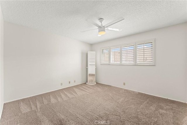 carpeted empty room featuring a textured ceiling and ceiling fan