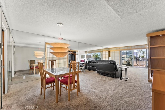 carpeted dining room featuring a textured ceiling