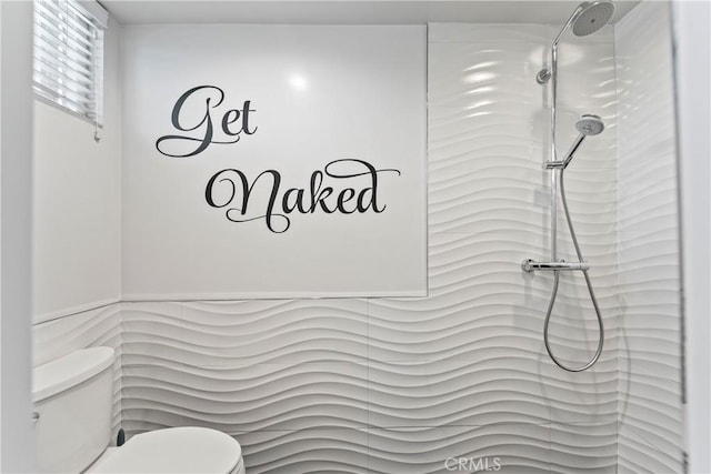 full bath with toilet and tiled shower