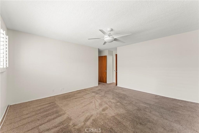 carpeted spare room featuring a ceiling fan and a textured ceiling