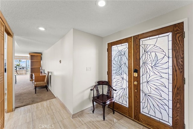 entryway featuring light carpet, a textured ceiling, french doors, recessed lighting, and baseboards