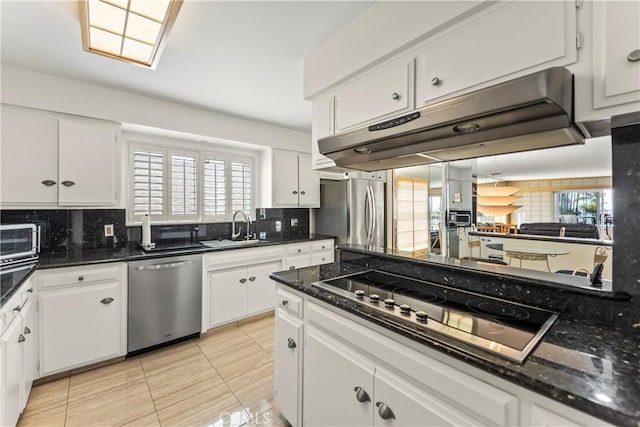 kitchen featuring decorative backsplash, under cabinet range hood, a wealth of natural light, and stainless steel appliances