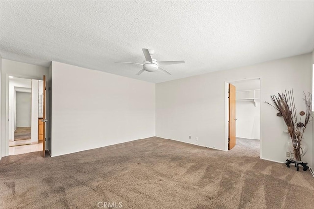 carpeted spare room with a ceiling fan and a textured ceiling