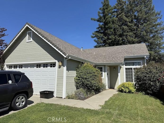 ranch-style house featuring an attached garage, driveway, and a front yard
