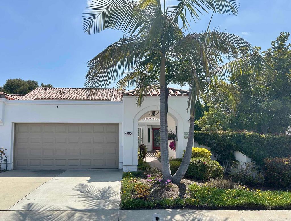 mediterranean / spanish house featuring a garage, a tiled roof, concrete driveway, and stucco siding
