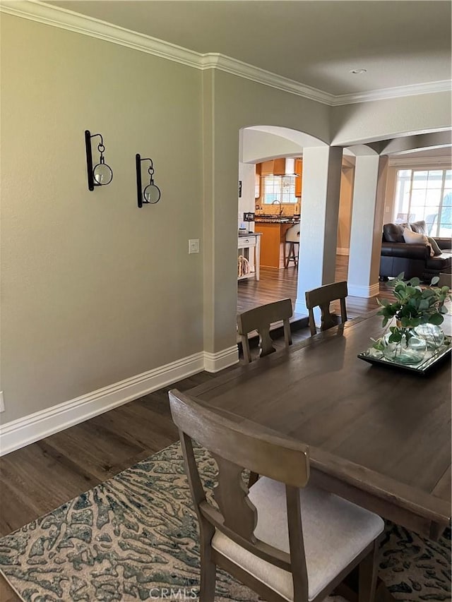 305 W 23rd St, Upland, CA 91784 - dining area featuring crown molding, arched walkways, baseboards, and wood finished floors
