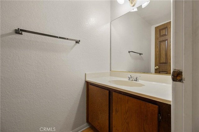 bathroom featuring vanity and a textured wall