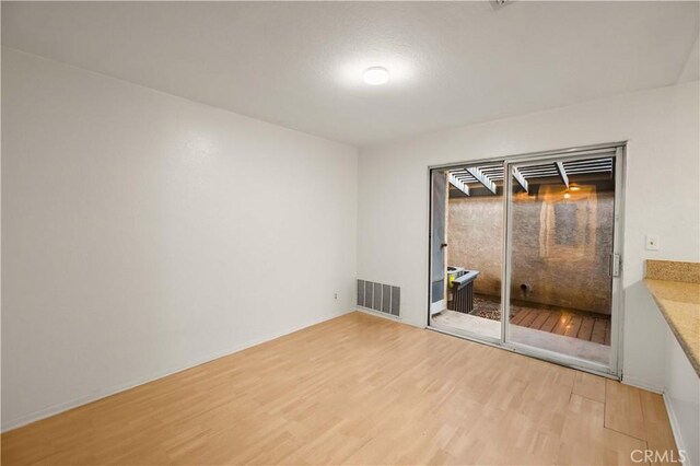 empty room featuring wood finished floors and visible vents