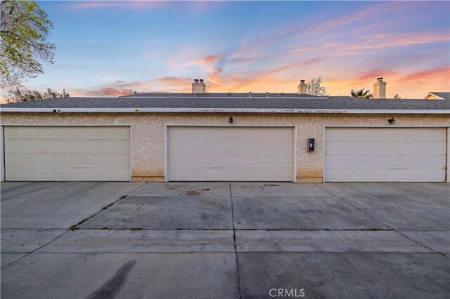 view of garage at dusk
