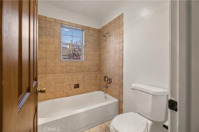 bathroom featuring toilet, washtub / shower combination, and tile patterned flooring