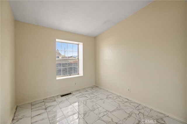 empty room featuring baseboards, visible vents, and marble finish floor