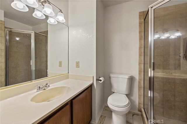 bathroom with vanity, baseboards, a shower stall, and toilet