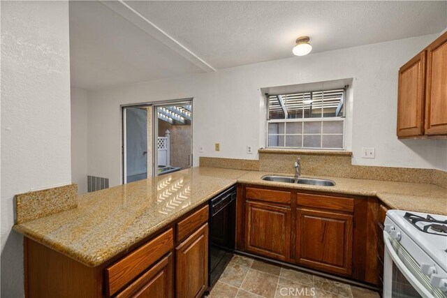 kitchen featuring brown cabinetry, visible vents, gas range gas stove, a sink, and black dishwasher